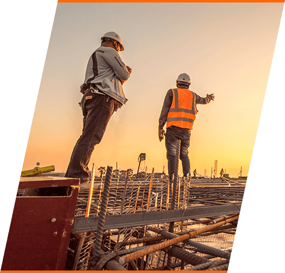 Two construction workers in sunset